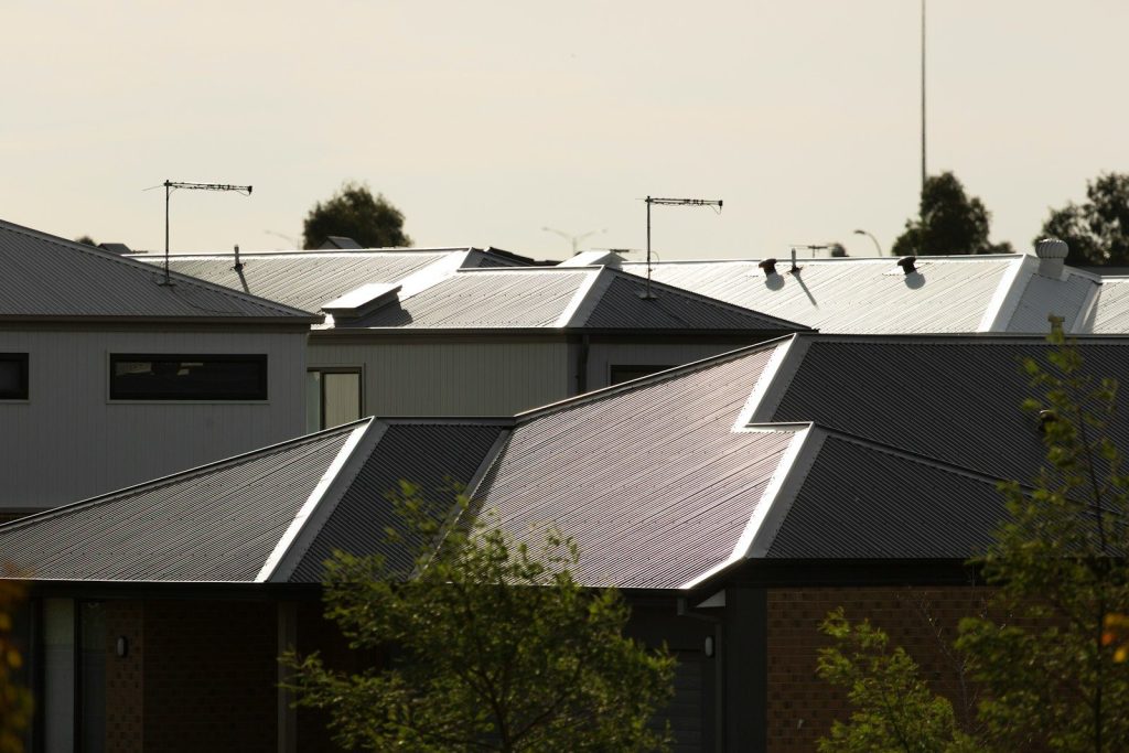 Here is a short caption: roofs of houses in daytime light.