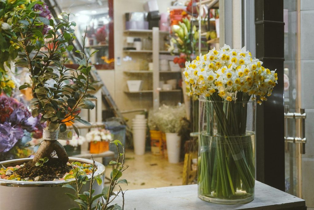 Fresh daffodils in a vase displayed inside a flower shop.