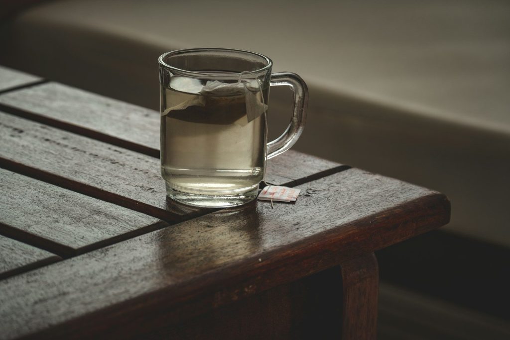 a glass of water sitting on top of a wooden table