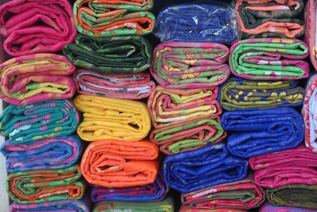 Folded blankets of various colors neatly stacked.