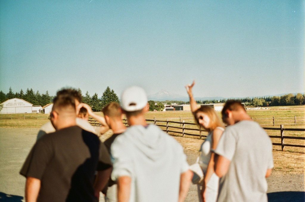 a group of people standing in front of a fence