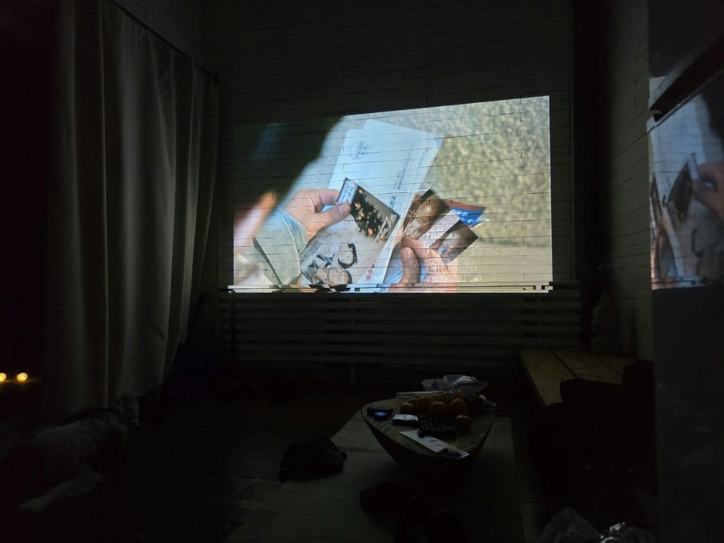 Hands holding a magazine in front of a projection screen.