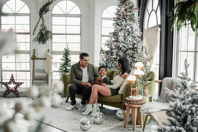 a man and woman sitting on a couch in front of a christmas tree