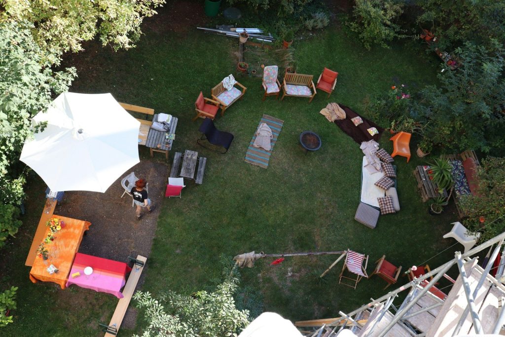 Garden party setup with diverse outdoor furniture and umbrella.