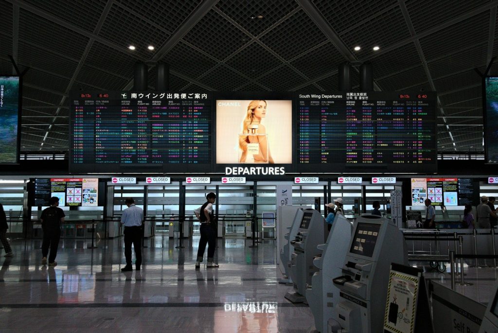 An airport terminal with a lot of electronic screens