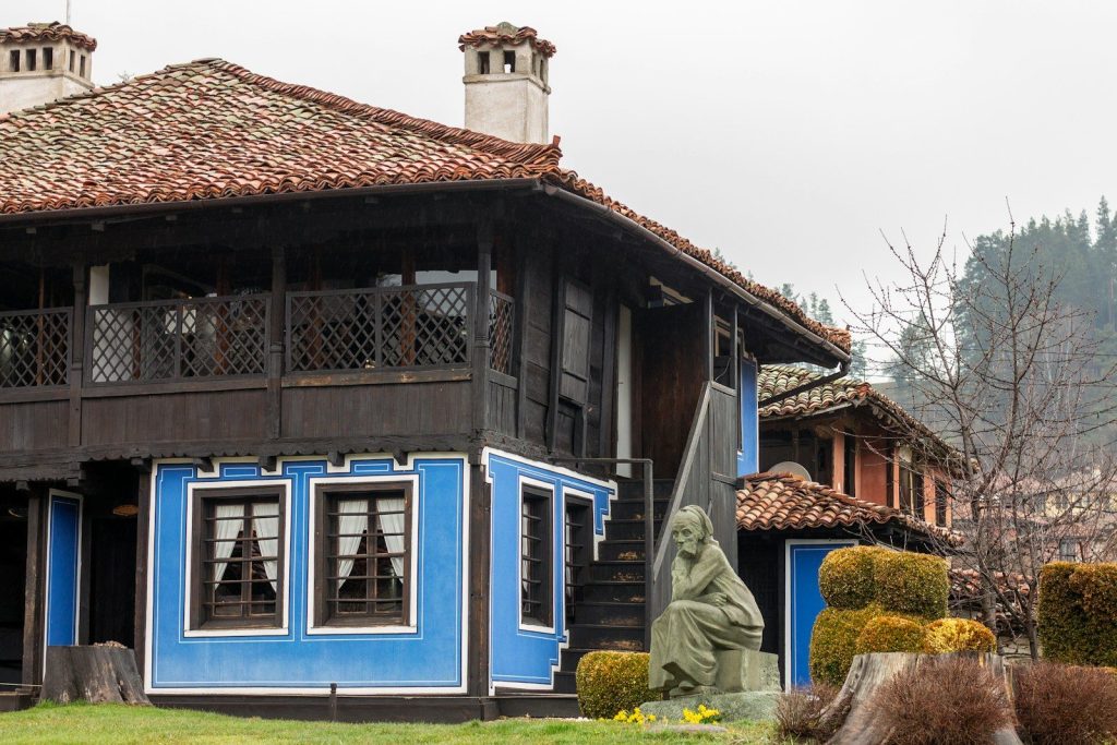 Historic blue house with a statue in the yard