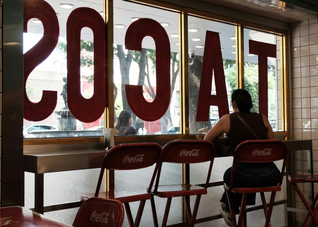 Woman sitting at a counter in a taco restaurant