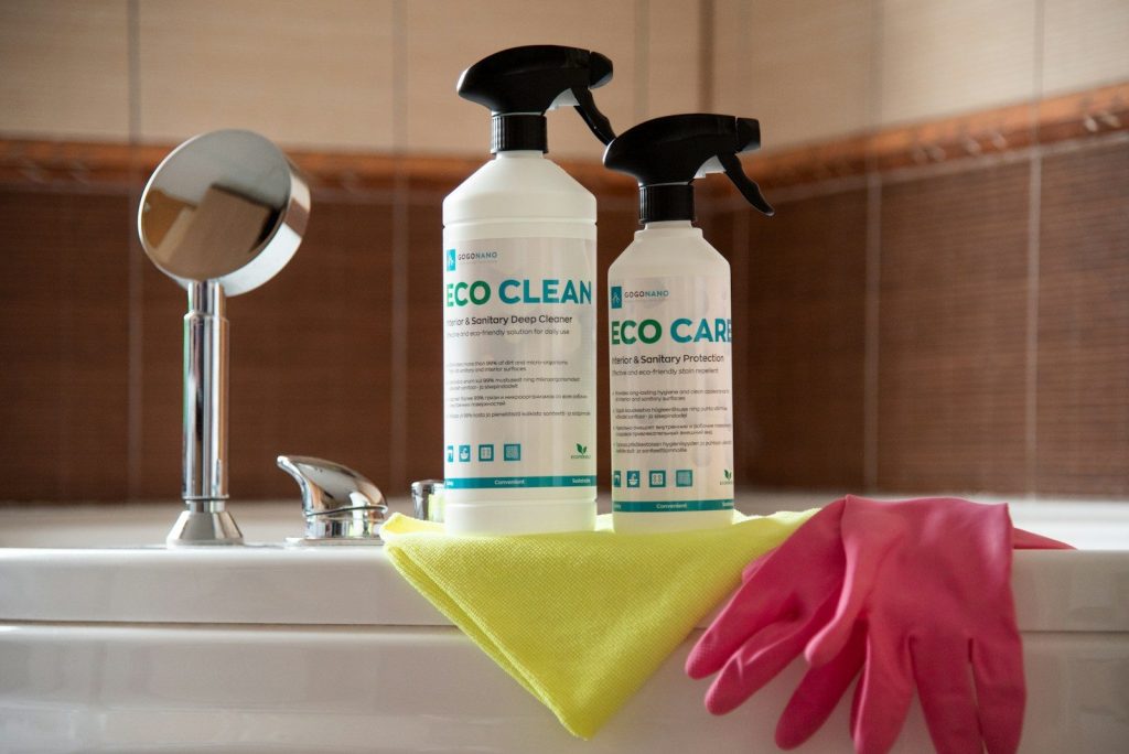 A pair of gloves and a sponge are sitting on a bathtub