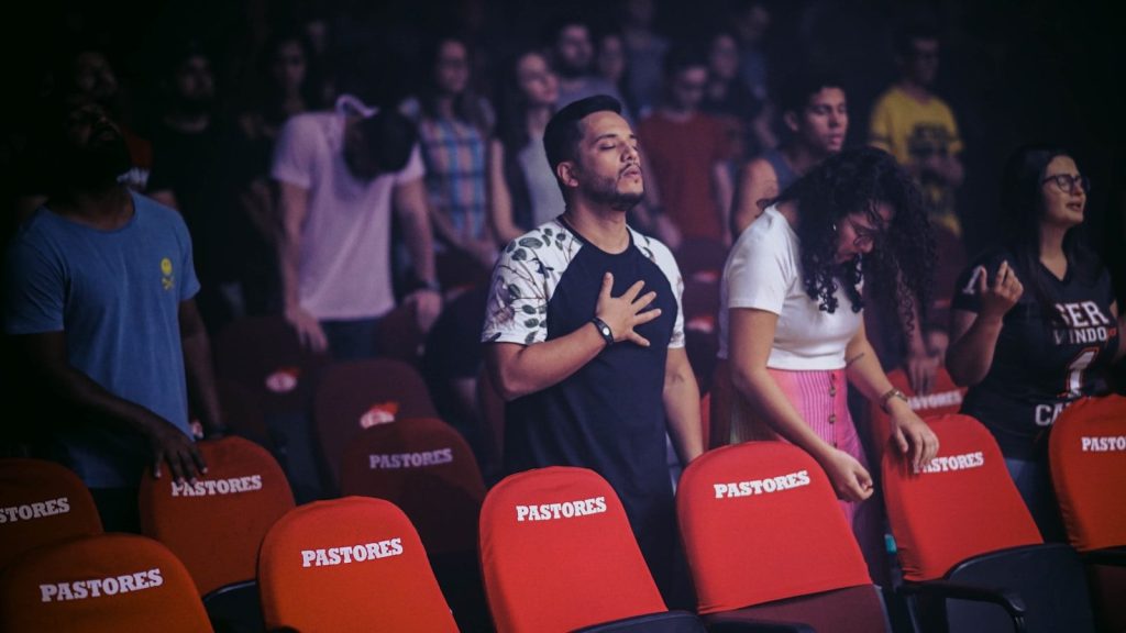man putting his hand on his chest while standing