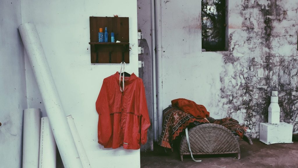 red long sleeve shirt hanged on white plastic clothes hanger