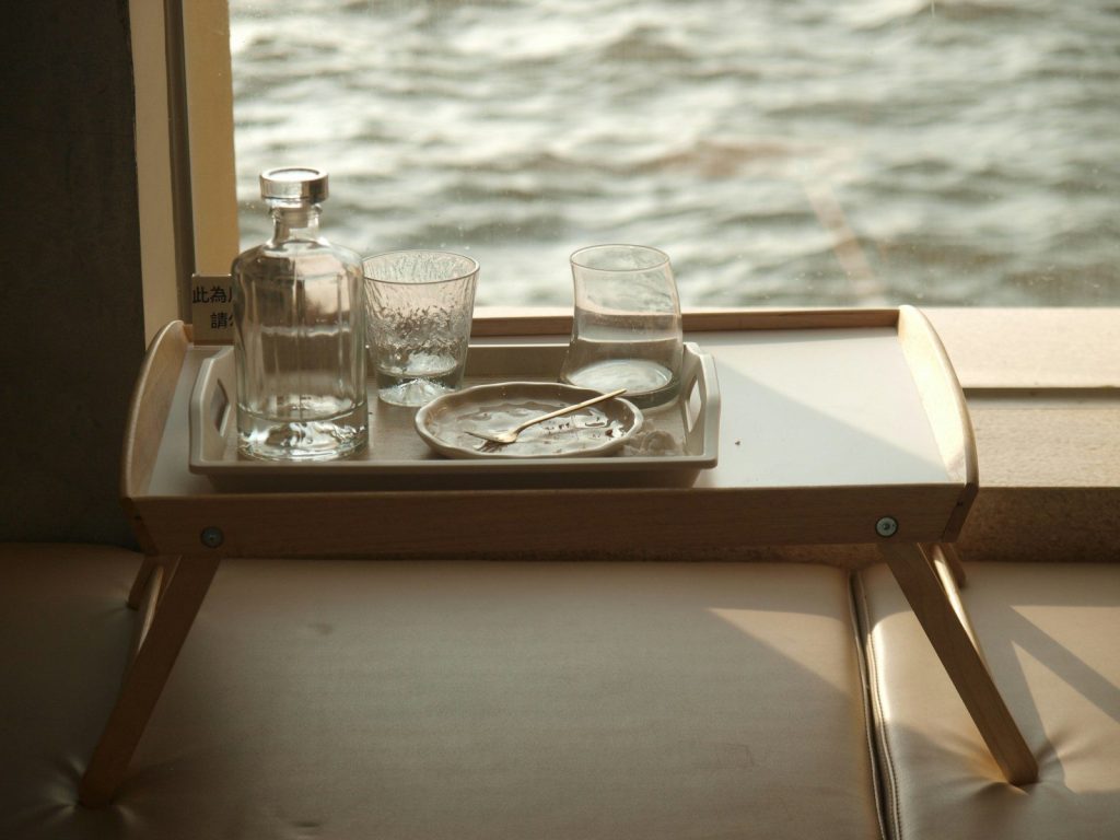 a tray with glasses and a bottle on a window sill