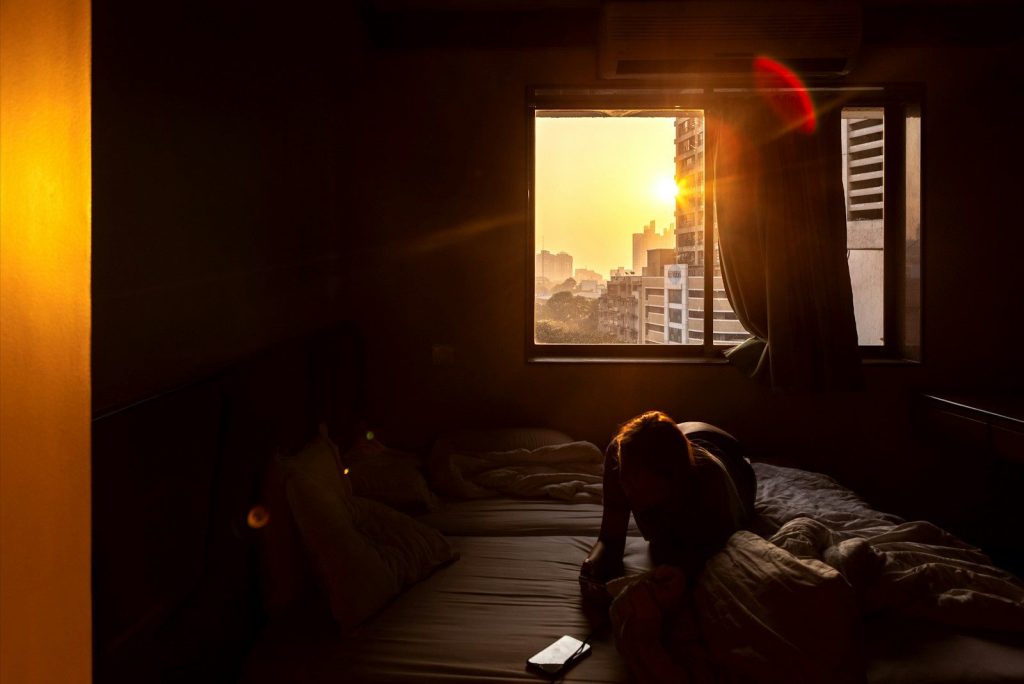 man in black shirt sitting on bed