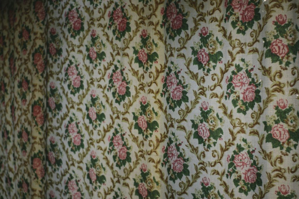Floral patterned wallpaper with pink roses and green leaves