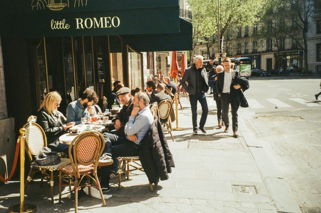 a group of people sitting at a table outside of a restaurant