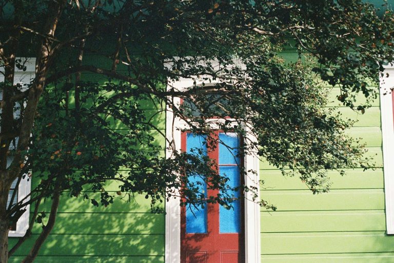 Green building with red door and blue windows