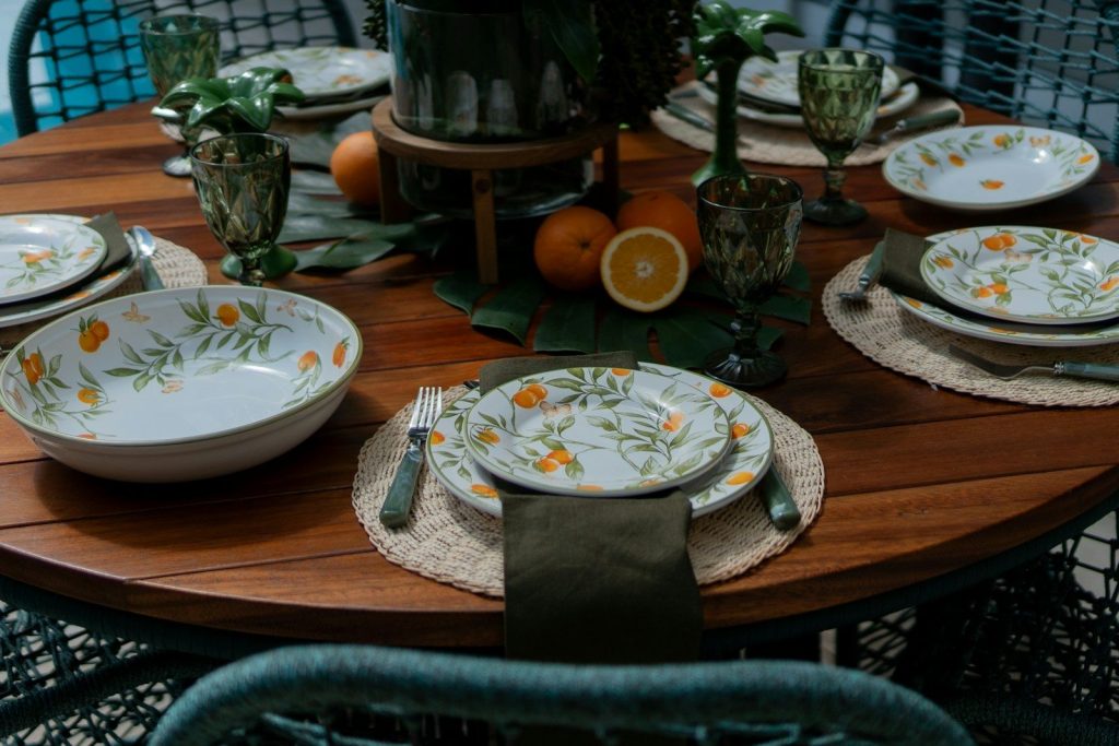 a wooden table topped with plates and bowls