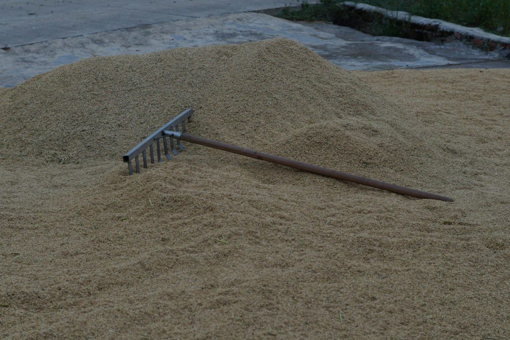 a pile of sand with a rake sticking out of it