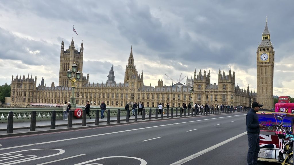 The houses of parliament and big ben under cloudy skies.