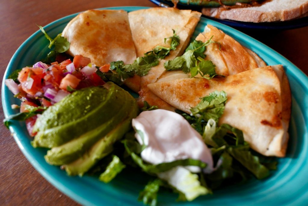 a plate of food with tortillas and guacamole