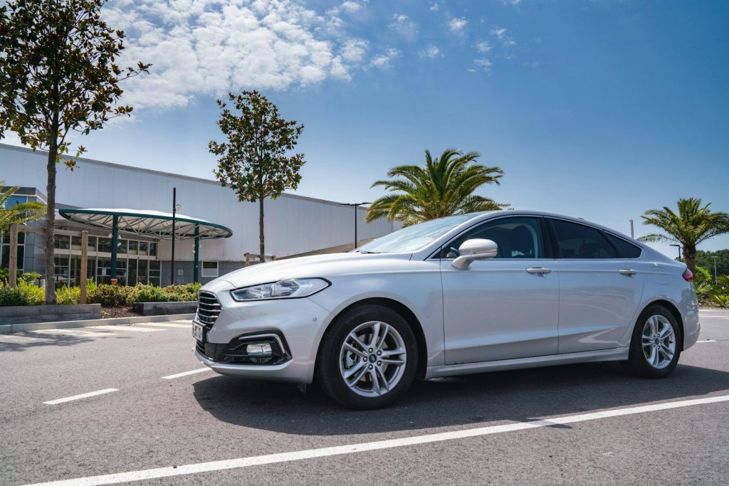 Silver sedan parked in front of a modern building.