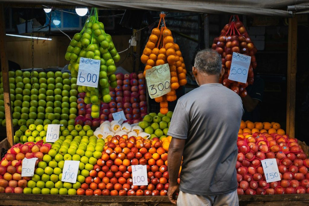 Man looking at a vibrant fruit stand.