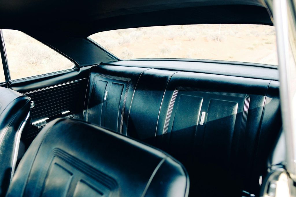 Interior of a vintage car with black seats.