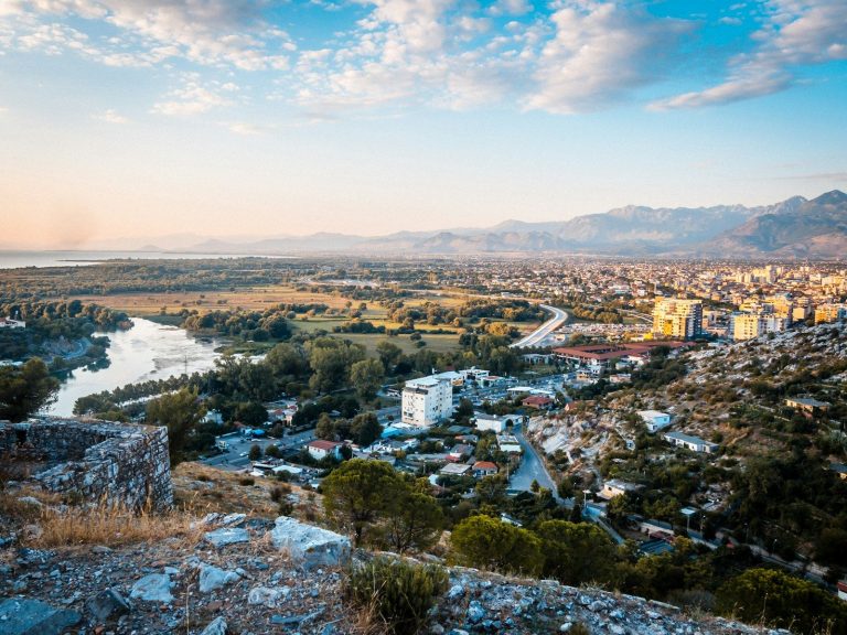 A city view with river under a blue sky.
