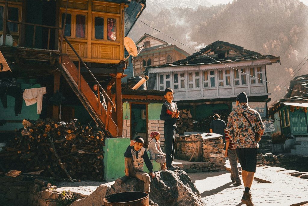People in a rustic village with traditional architecture.