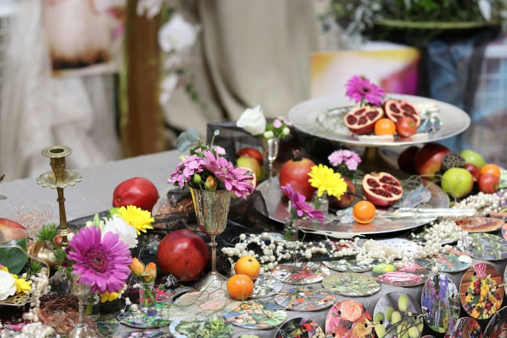 a table topped with plates of fruit and flowers