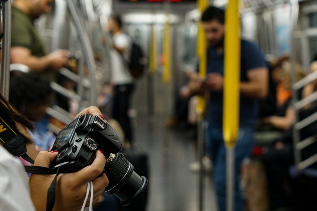 selective photography of person holds DSLR camera
