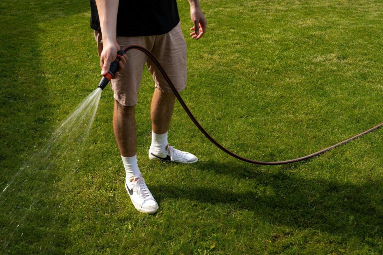 a man is spraying water on the grass